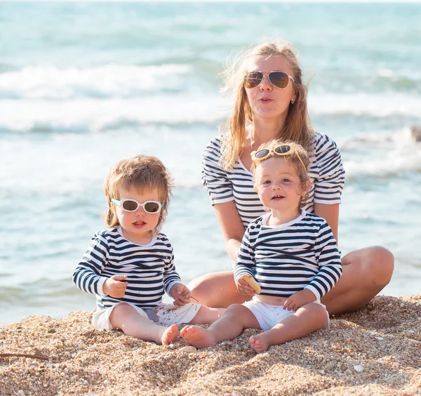 Mère avec des enfants sur la plage — Photo