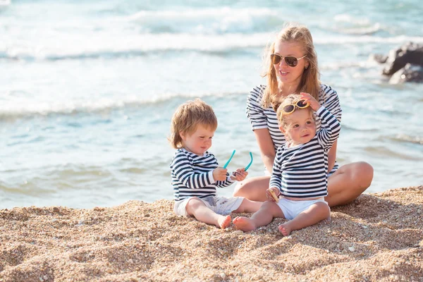 Moeder met kinderen op het strand — Stockfoto