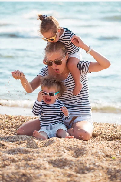 Moeder met kinderen op het strand — Stockfoto