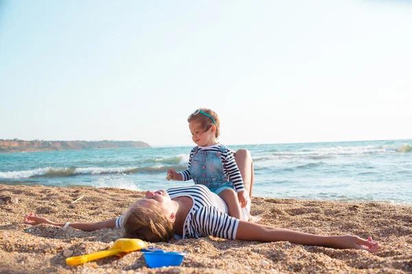 Mamma med dotter på stranden — Stockfoto