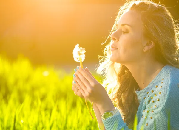 Mujer soplando diente de león — Foto de Stock