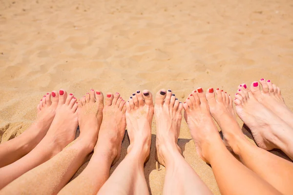 Nohy z pěti dívek na pláži — Stock fotografie
