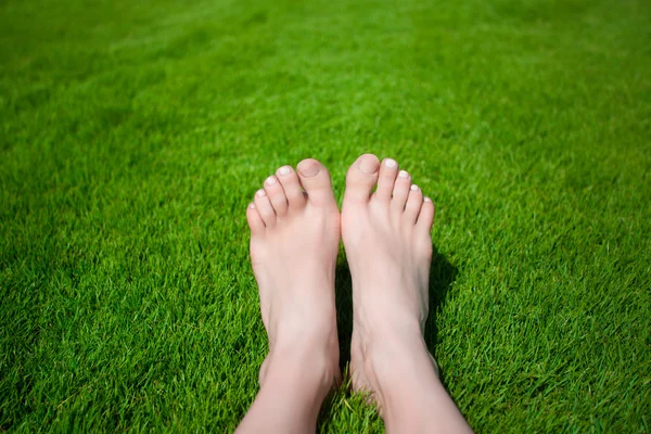 Woman legs on the green grass — Stock Photo, Image