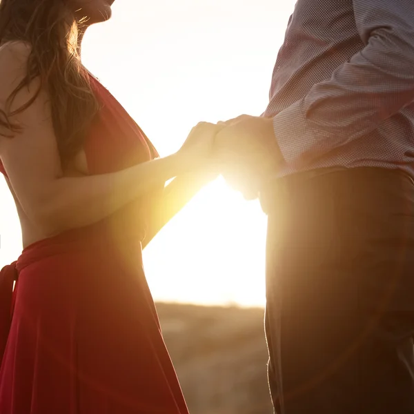 Woman and man holding hands on sunrise — Stock Photo, Image