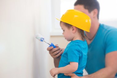 Çocuk babasının yanında duvara boyalı