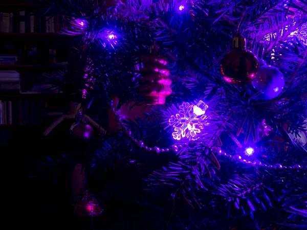 Iluminación del árbol de Navidad en una habitación oscura — Foto de Stock