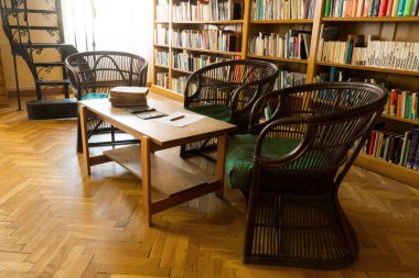 Sandalyeleri ve dal sandalyeleri olan eski bir kütüphanenin iç tasarımı.