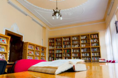 Masasında kitap olan eski bir kütüphanenin iç tasarımı.