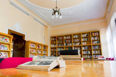 Masasında kitap olan eski bir kütüphanenin iç tasarımı.