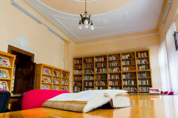 Masasında kitap olan eski bir kütüphanenin iç tasarımı.