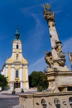 Macaristan 'ın Szekszard kentindeki Kral Bela caddesindeki Katolik Kilisesi ve Kutsal Üçlü Sütun.