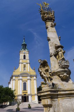 Macaristan 'ın Szekszard kentindeki Kral Bela caddesindeki Katolik Kilisesi ve Kutsal Üçlü Sütun.