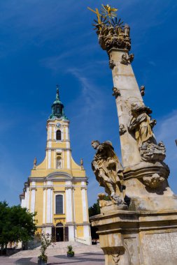 Macaristan 'ın Szekszard kentindeki Kral Bela caddesindeki Katolik Kilisesi ve Kutsal Üçlü Sütun.