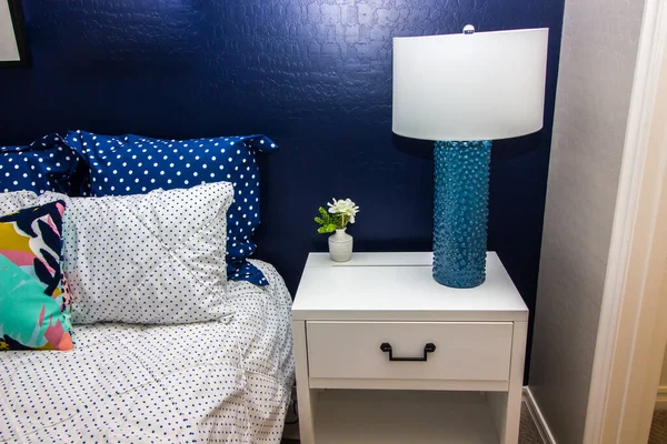 Bedroom with Nightstand, Lamp & Blue Accent Wall