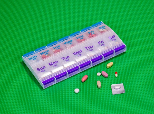 グリーンパターン上の医療薬と薬の容器の背景 — ストック写真