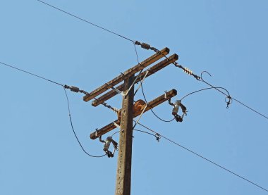 Mavi gökyüzü tarafından çerçevelenmiş bir elektrik direği detayı