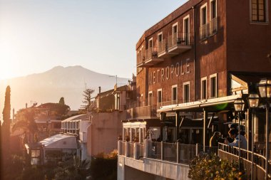 Taormina, İtalya, 31 Aralık 2019: İnsanlar Taormina, Silicy, İtalya 'daki Metropole balkonundan gün batımını izliyor