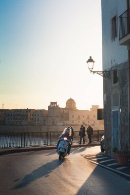 Syracuse, Sicilya, 2 Ocak 2020: Günbatımında Siraküza seti boyunca yürüyen yayalar