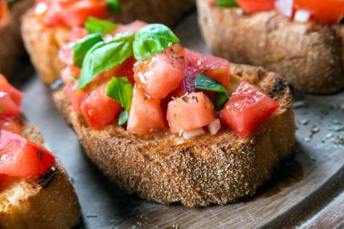 Lezzetli klasik bruschetta, taze domates, zeytinyağı, kekik ve fesleğen, İtalyan aperatifi 
