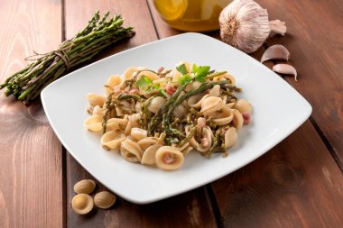 Bir tabak lezzetli orkide, yabani kuşkonmaz, domuz pastırması, İtalyan mutfağı. 