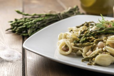 Bir tabak lezzetli orkide, yabani kuşkonmaz, domuz pastırması, İtalyan mutfağı. 