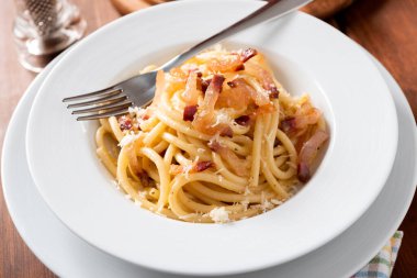 Lezzetli bukatini alla carbonara tabağı, yumurta, guanciale ve pecorino ile geleneksel bir makarna tarifi, İtalyan mutfağı. 