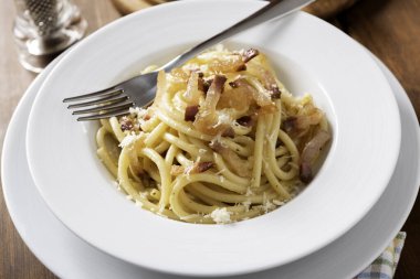 Lezzetli bukatini alla carbonara tabağı. Yumurtalı İtalyan makarnası, guanciale ve pecorino tarifi. 