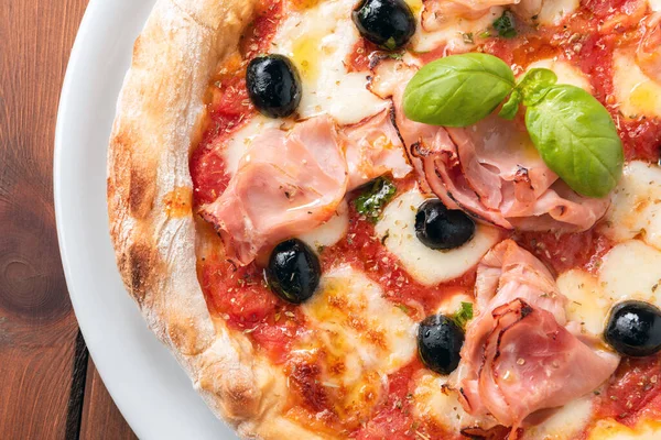 delicious italian pizza with prosciutto cotto ham, mozzarella, tomato sauce and black olives