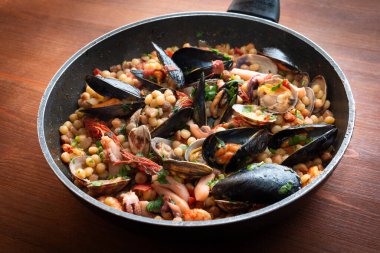 Deniz ürünleri soslu fregula, geleneksel sardalya makarnası, İtalyan mutfağı. 