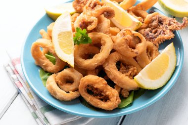 Kızarmış kalamar halkaları ve limon dilimleri.