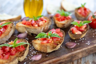 Domates ve fesleğenle kaplı çıtır ekmek.