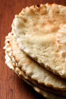 Ahşap masada ev yapımı pide yığını.