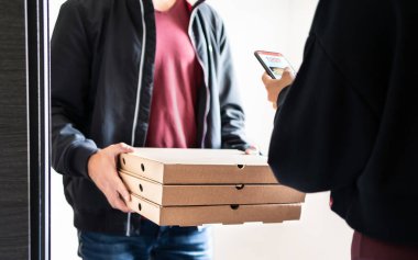 Pizza teslimatı cep telefonuyla çevrimiçi siparişten sonra eve geliyor. Fast food kutuları ve müşterileri elinde tutan dağıtıcı akıllı telefon uygulamasını kullanarak ödeme, bahşiş veya değerlendirme yapıyor. Restoran teslimat servisi.