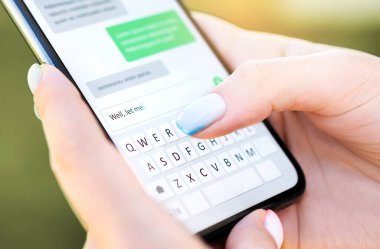 Cep telefonlu mesaj. Akıllı telefondan SMS atan bir kadın. Kedi balığı ya da dijital dolandırıcılık. Mesajlaşma sohbetinde ekran klavyesi. Makro parmak yazmayı kapat. Erkek arkadaşınla konuş..