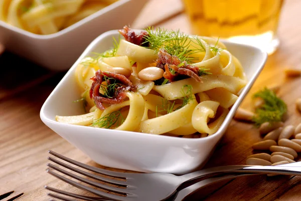 Noodles with anchovies, pine nuts and fennel — Stock Photo, Image