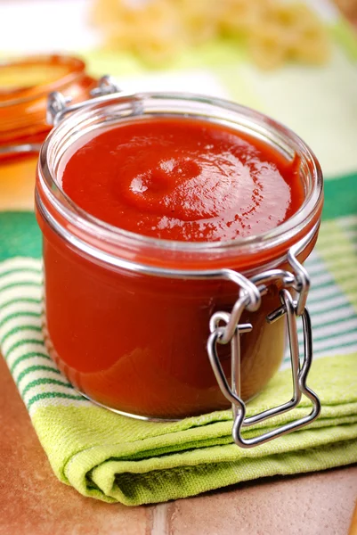 Tomato sauce in glass jar — Stock Photo, Image