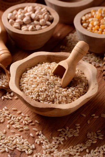 Brown rice in foreground — Stock Photo, Image