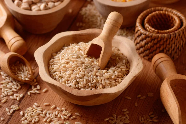 Brown rice in foreground — Stock Photo, Image