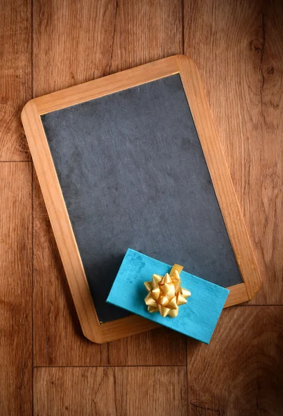Gift package on the blackboard — Stock Photo, Image