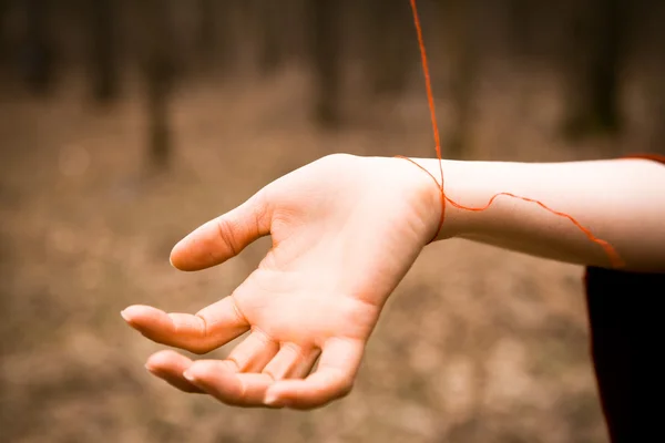 Kadınların elleri ile kırmızı iplik bağlı