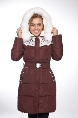 Uzun bir ceket kürk başlık ile genç güzel sarışın kadın