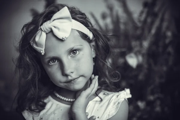 Beautiful little girl with a rim in the form of a bow — Stock Photo, Image