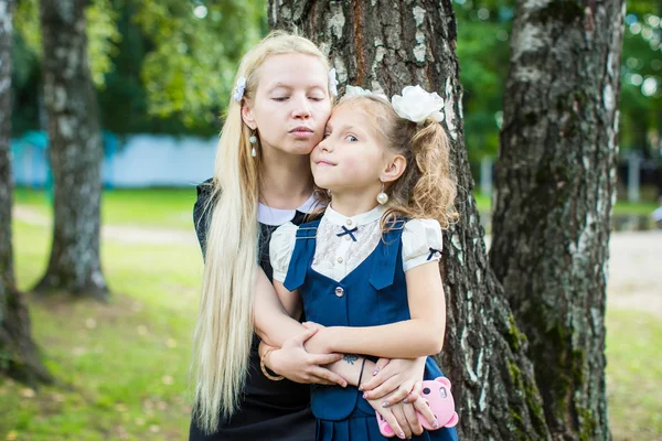 Chica en uniforme escolar con madre — Foto de Stock