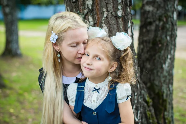 Flicka i skoluniform som med mamma — Stockfoto