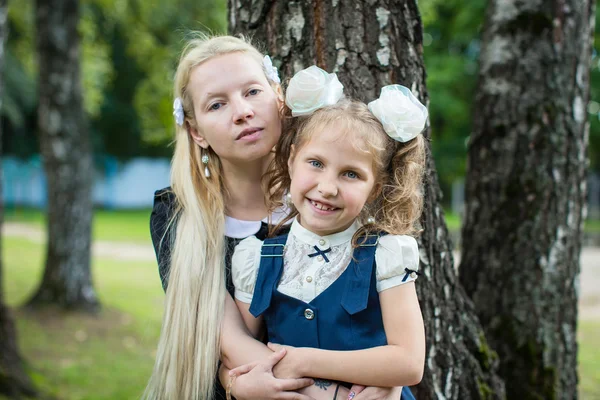 Flicka i skoluniform som med mamma — Stockfoto