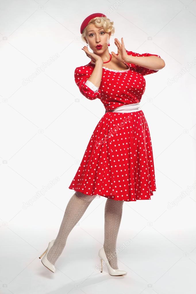 Young beautiful blonde in red dress pin-up in the studio