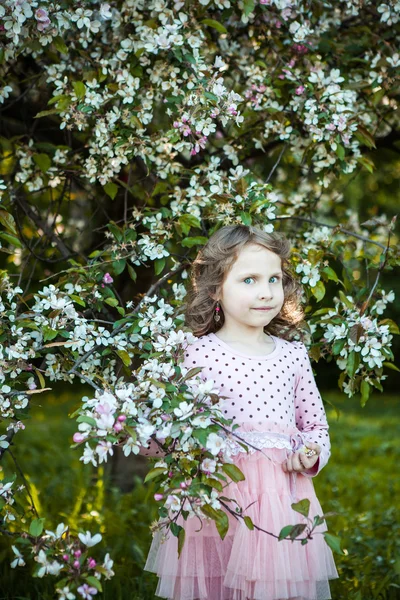 Красива блондинка блакитноока дівчина в квітковому яблучному саду — стокове фото