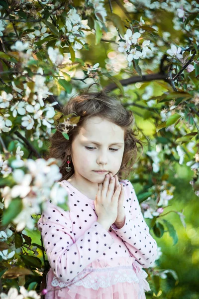 Linda loira menina de olhos azuis em um pomar de maçã florido — Fotografia de Stock