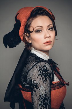 Keçe şapka, uzun siyah etek ve kırmızı korse genç güzel esmer kadın