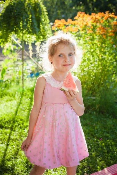 Linda menina loira de olhos azuis comendo melancia ao ar livre — Fotografia de Stock